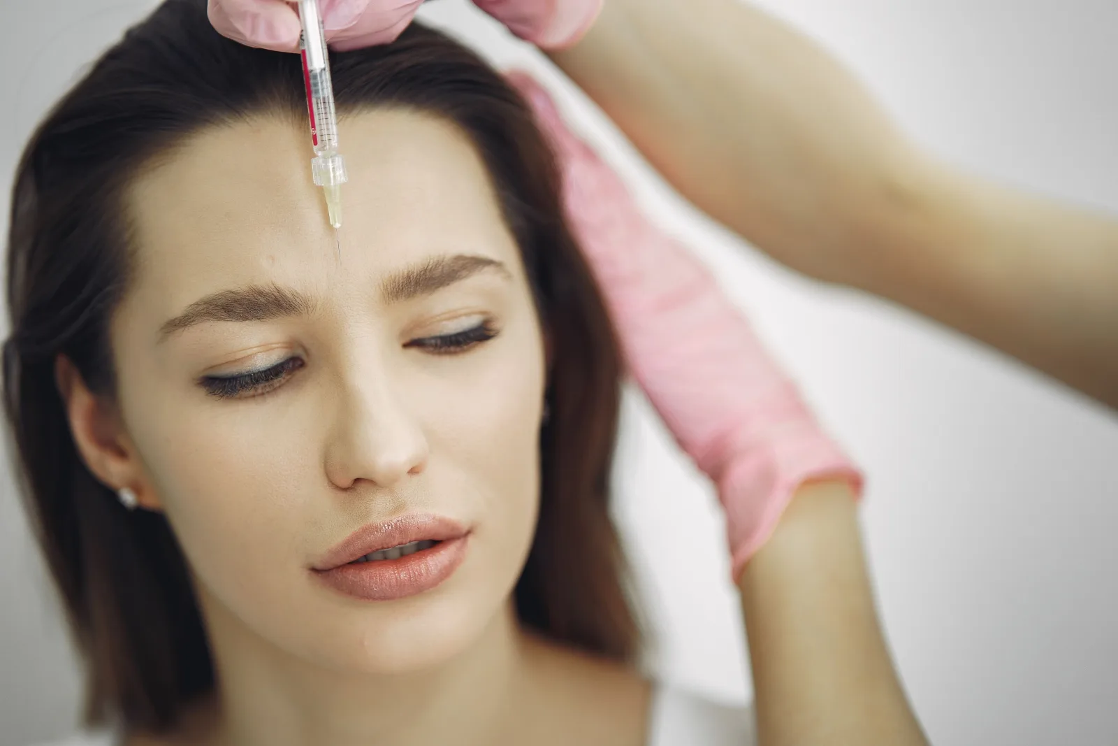 Cosmetic injection being carried out by a gloved professional in a clean clinic setting in Malta